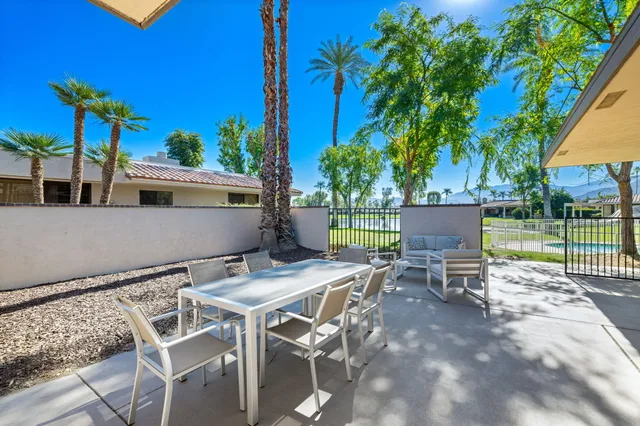 a view of a patio with table and chairs and potted plants