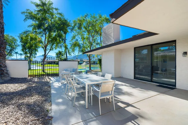 a view of a patio with table and chairs potted plants