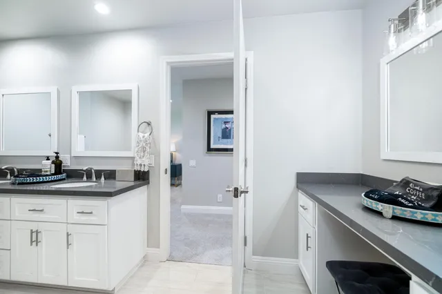 a bathroom with a granite countertop sink a mirror and shower