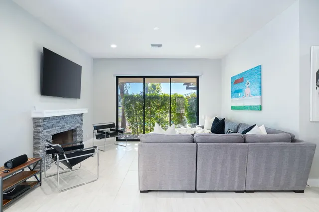 a living room with furniture a fireplace and a flat screen tv