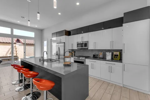 a kitchen with stainless steel appliances a stove a sink a refrigerator and cabinets
