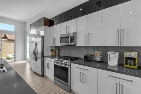 a kitchen that has a lot of cabinets a sink and appliances in it