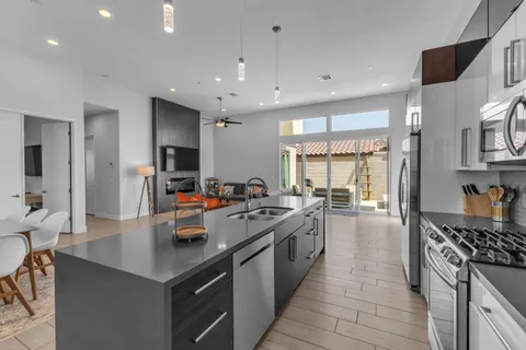 a kitchen with stainless steel appliances a sink a stove top oven a counter space and cabinets