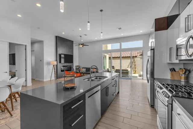 a kitchen with stainless steel appliances a sink a stove top oven a counter space and cabinets