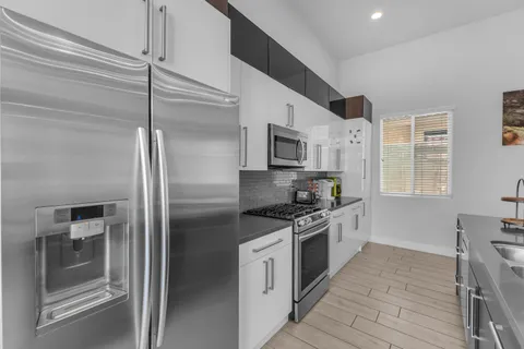 a kitchen with stainless steel appliances granite countertop a sink stove and refrigerator
