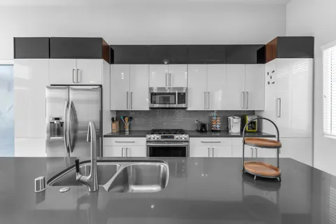 a kitchen with sink a counter top space and living room view