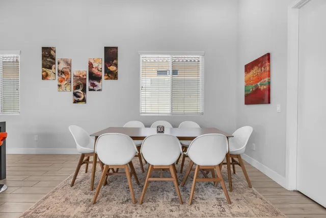 a large kitchen with stainless steel appliances kitchen island granite countertop a living room and white cabinets