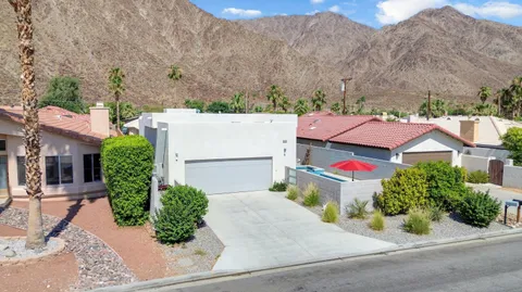 an aerial view of a house with a yard and mountain view in back
