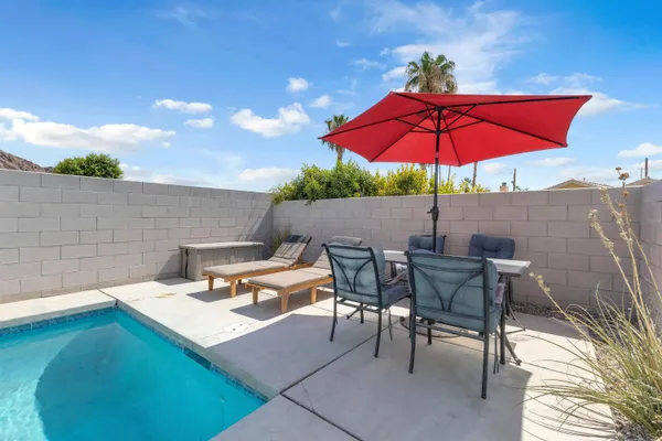 an outdoor sitting area with furniture and umbrella