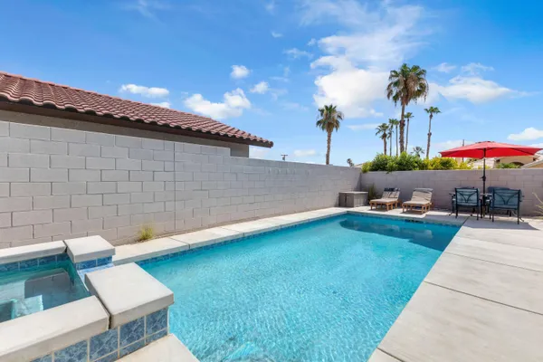 a backyard of a house with table and chairs