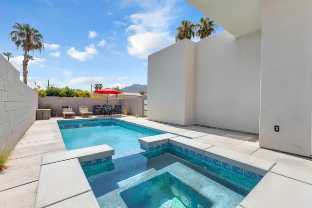 a backyard of a house with table and chairs