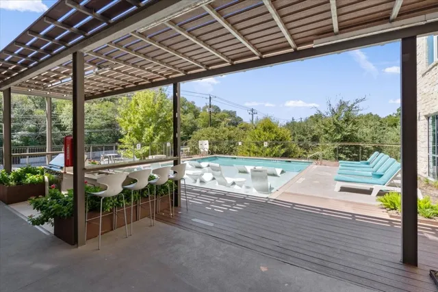 a view of a patio with couches table and chairs with wooden floor and fence