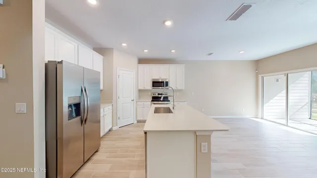 a kitchen with stainless steel appliances a refrigerator and a stove top oven