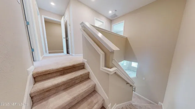 a view of staircase with railing and white walls