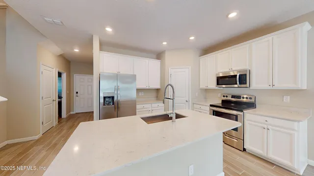 a kitchen with stainless steel appliances kitchen island granite countertop a refrigerator and a stove top oven