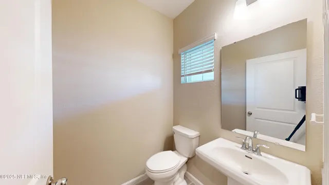 a bathroom with a toilet a sink and mirror