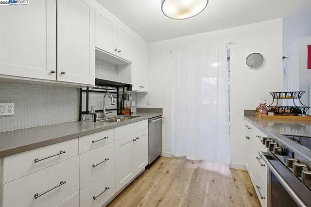 a kitchen with granite countertop white cabinets and white appliances