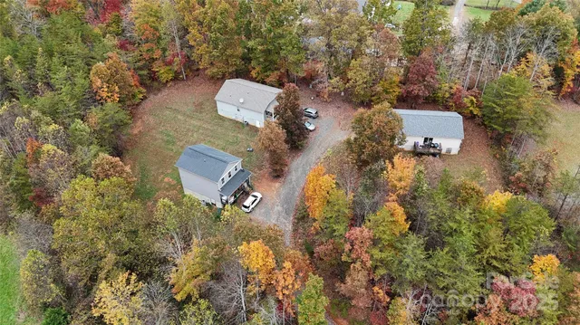 an aerial view of house with yard and mountain view in back