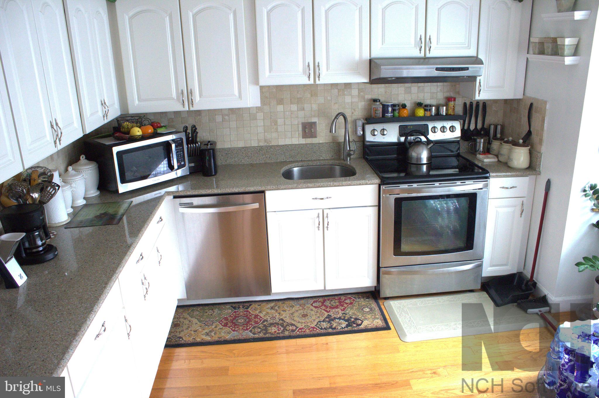1902 Valley Terrace Southeast Washington, DC 20032 - Photo 3 of 33 a kitchen with a stove a microwave and refrigerator