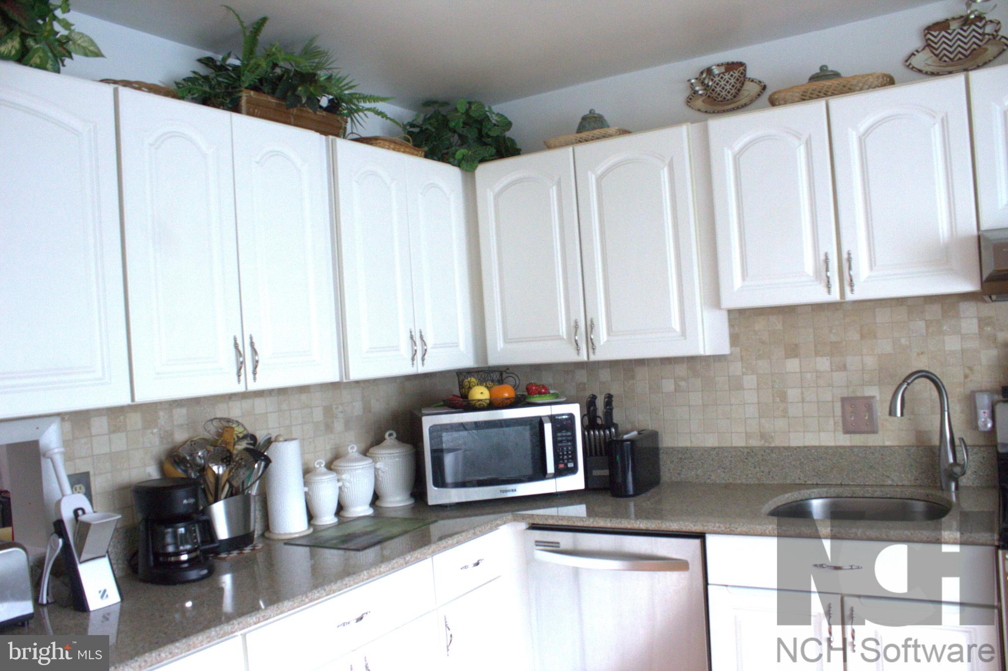 1902 Valley Terrace Southeast Washington, DC 20032 - Photo 4 of 33 a kitchen with white cabinets a sink and dishwasher