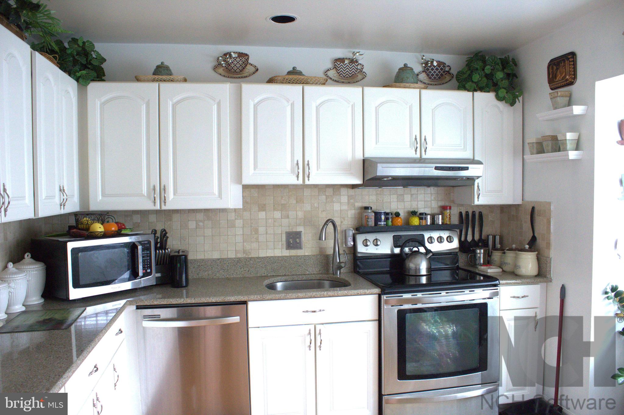 1902 Valley Terrace Southeast Washington, DC 20032 - Photo 5 of 33 a kitchen with stainless steel appliances granite countertop a refrigerator a stove and white cabinets