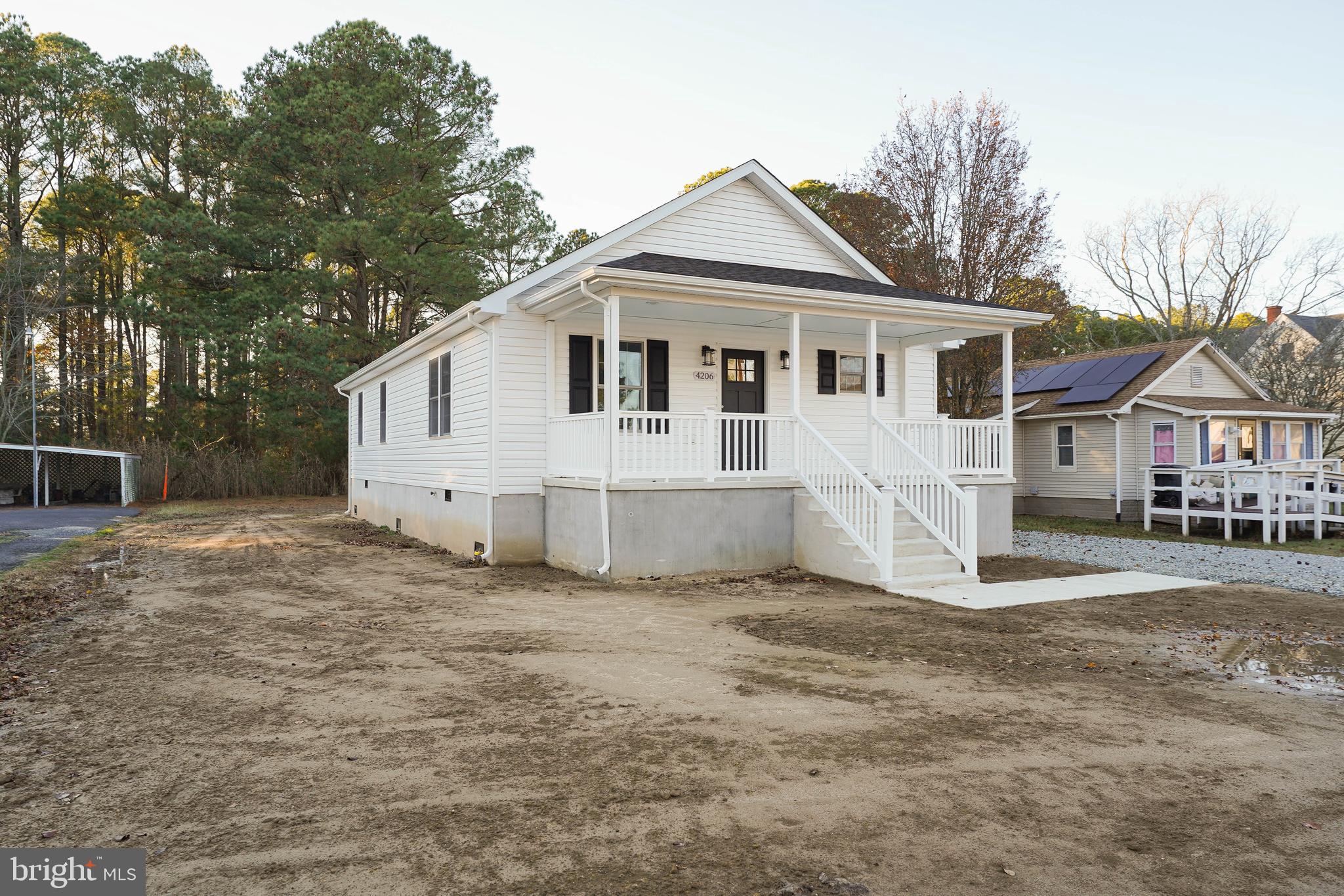 4206 Jacksonville Road Crisfield, MD 21817 - Photo 2 of 34 a view of a white house with a yard and large trees