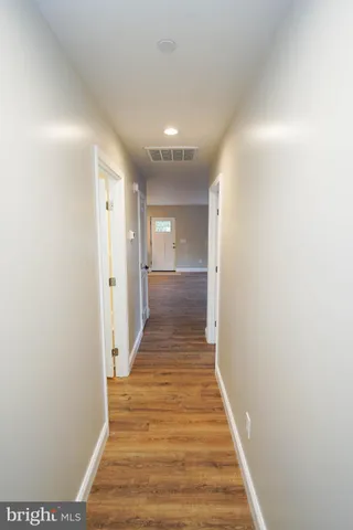 an empty room with chandelier fan and windows