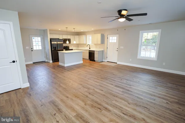 a kitchen with a sink a refrigerator a microwave and cabinets