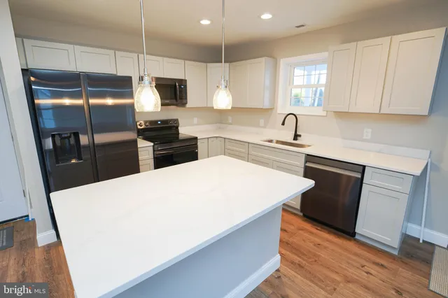 a kitchen with stainless steel appliances a refrigerator sink and microwave