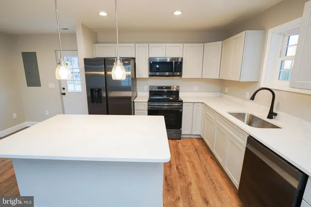 a kitchen with stainless steel appliances a refrigerator sink and microwave