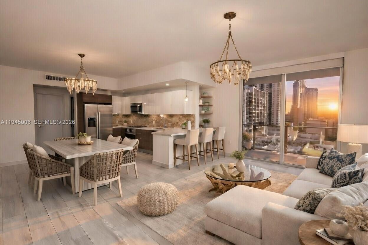 1010 Southwest 2nd Avenue, Unit 1703 Miami, FL 33130 - Photo 4 of 8 a living room with furniture a chandelier and kitchen view