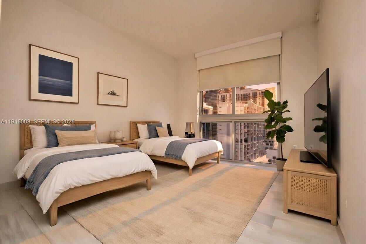 1010 Southwest 2nd Avenue, Unit 1703 Miami, FL 33130 - Photo 8 of 8 a spacious bedroom with two beds and a couch