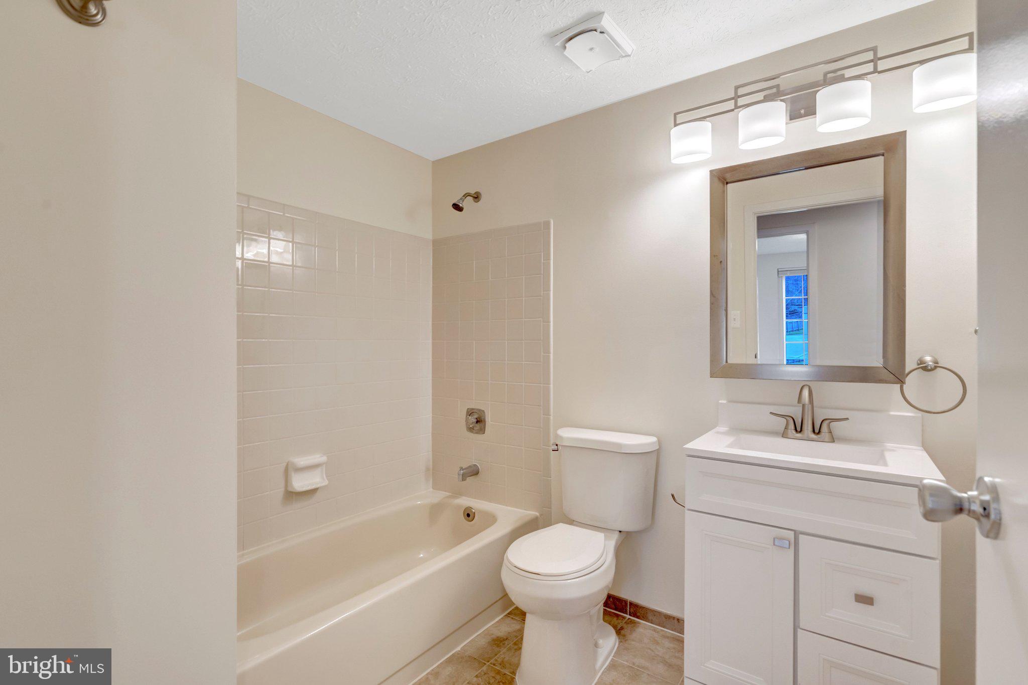 7743 Middle Valley Drive Springfield, VA 22153 - Photo 8 of 17 a bathroom with a sink toilet a mirror and shower