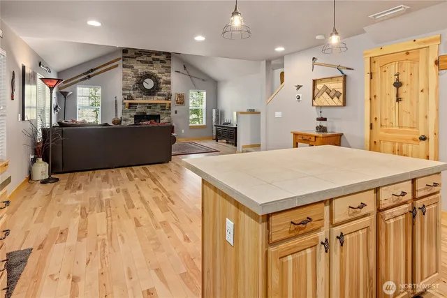 a kitchen with kitchen island a counter top space a sink stainless steel appliances and cabinets