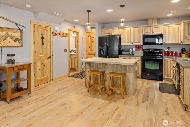 a kitchen with stainless steel appliances granite countertop a refrigerator a stove top oven and a sink