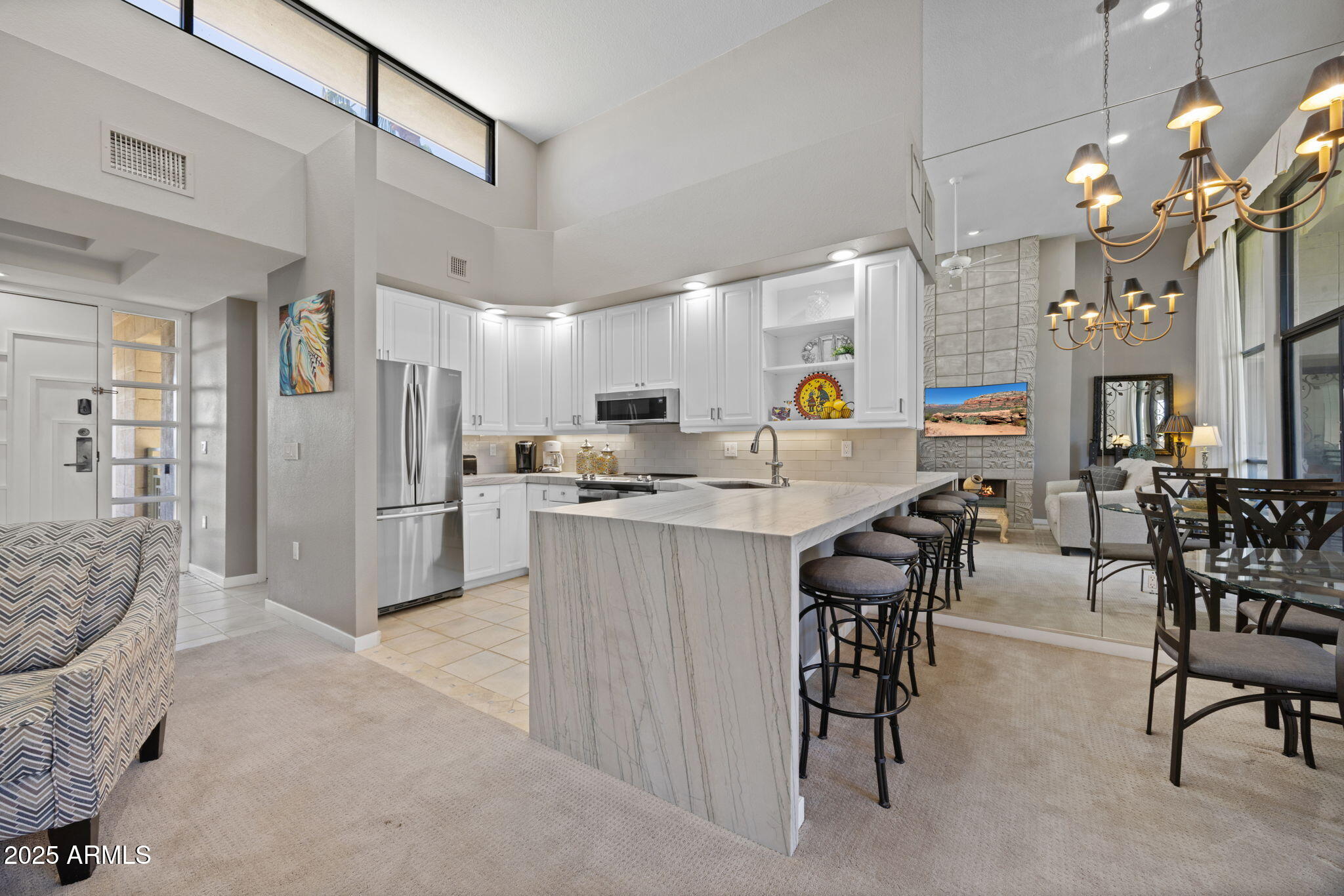 2802 East Camino Acequia Drive, Unit 8 Phoenix, AZ 85016 - Photo 12 of 34 a kitchen with stainless steel appliances kitchen island granite countertop a refrigerator a stove a dining table and chairs with wooden floor