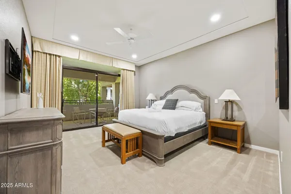 a bedroom with a bed and a flat tv screen on wall