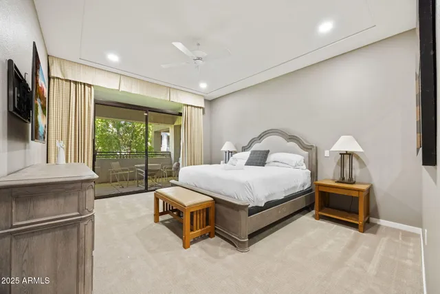 a bedroom with a bed and a flat tv screen on wall