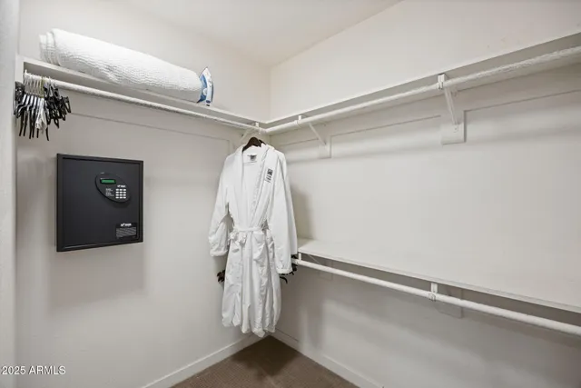 a view of walk in closet with clothes
