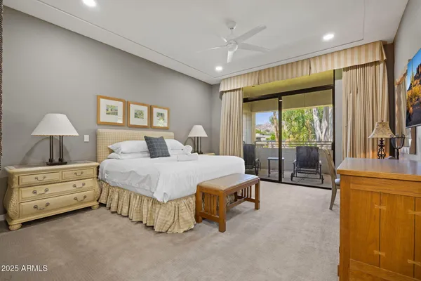 a spacious bedroom with a bed and a dresser next to a window