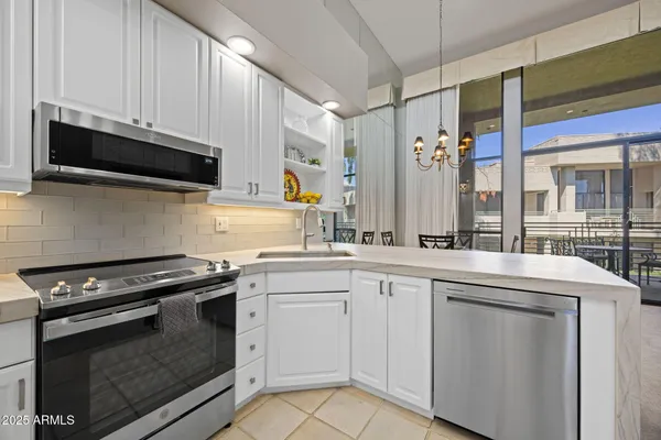a kitchen with stainless steel appliances granite countertop a stove and a microwave