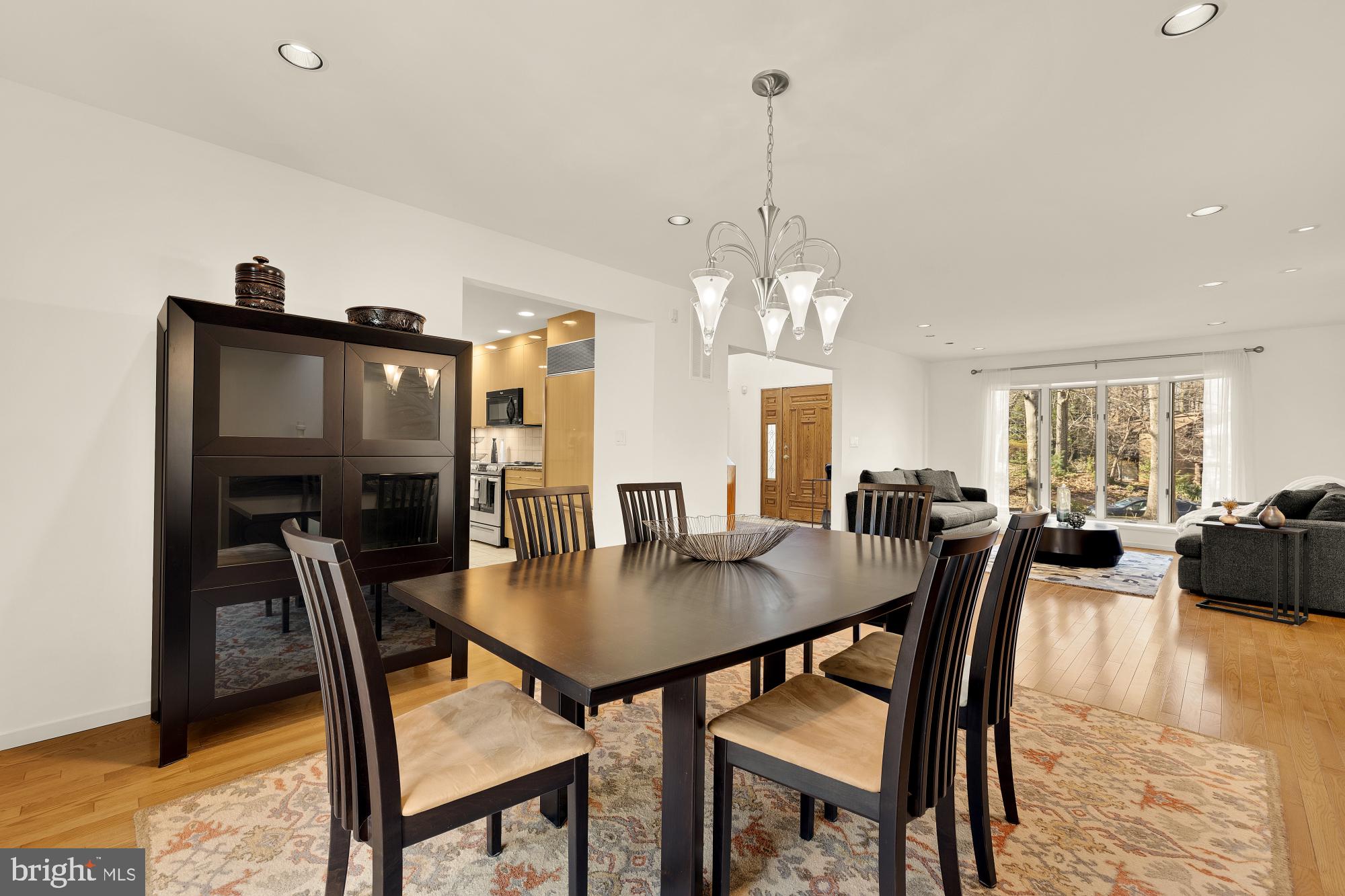 10419 Crossing Creek Road Potomac, MD 20854 - Photo 19 of 74 a view of a dining room and livingroom with furniture wooden floor a rug a potted plant and a chandelier