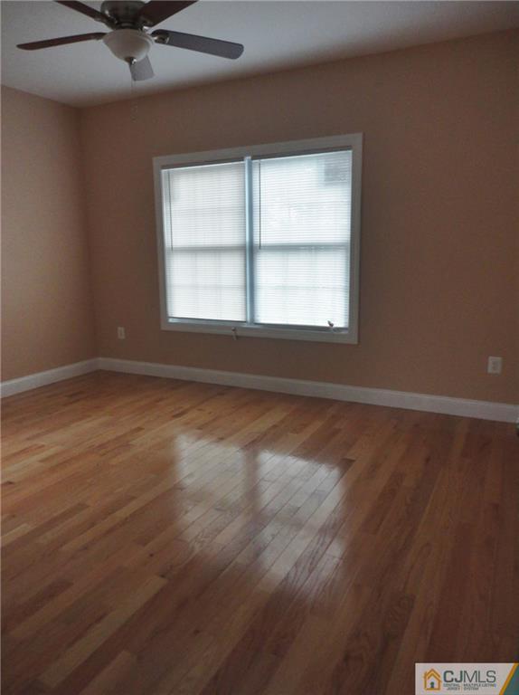 715 Spruce Road North Brunswick, NJ 08902 - Photo 11 of 23 an empty room with wooden floor and windows