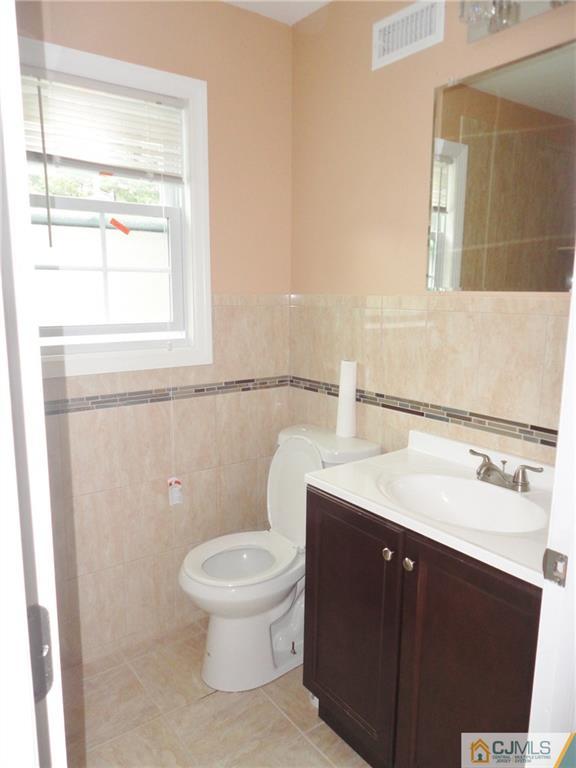 715 Spruce Road North Brunswick, NJ 08902 - Photo 16 of 23 a bathroom with a toilet a sink and a mirror
