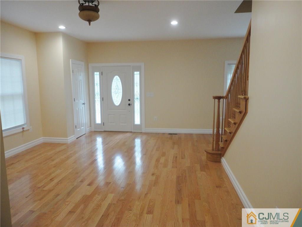 715 Spruce Road North Brunswick, NJ 08902 - Photo 4 of 23 an empty room with wooden floor and white walls