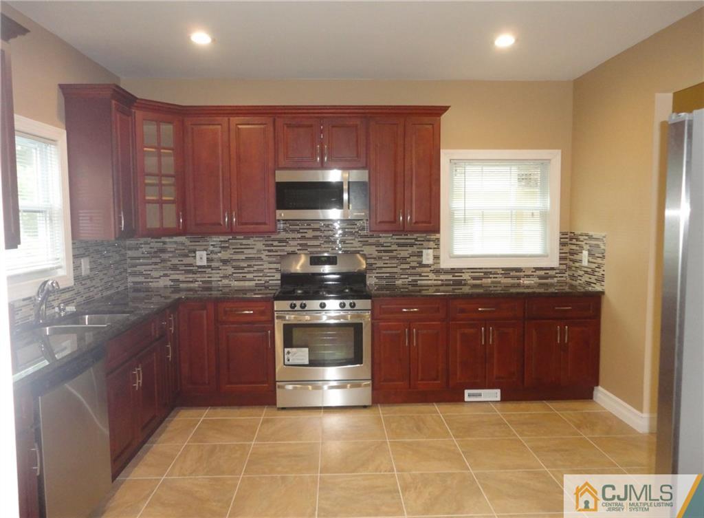 715 Spruce Road North Brunswick, NJ 08902 - Photo 8 of 23 a kitchen with granite countertop a stove top oven microwave and cabinets
