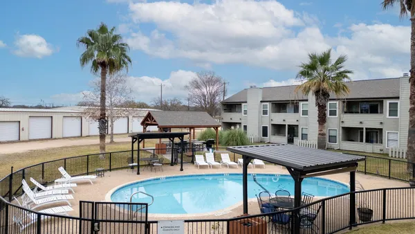 a view of a house with backyard and sitting area