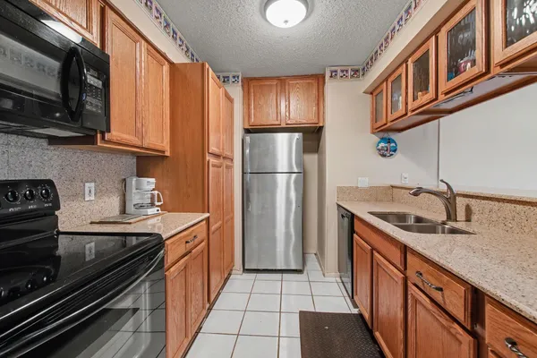 a kitchen with stainless steel appliances granite countertop a stove a sink and a refrigerator