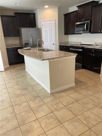 a kitchen with stainless steel appliances granite countertop a sink a stove a microwave and cabinets