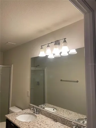 a bathroom with a granite countertop sink and a mirror
